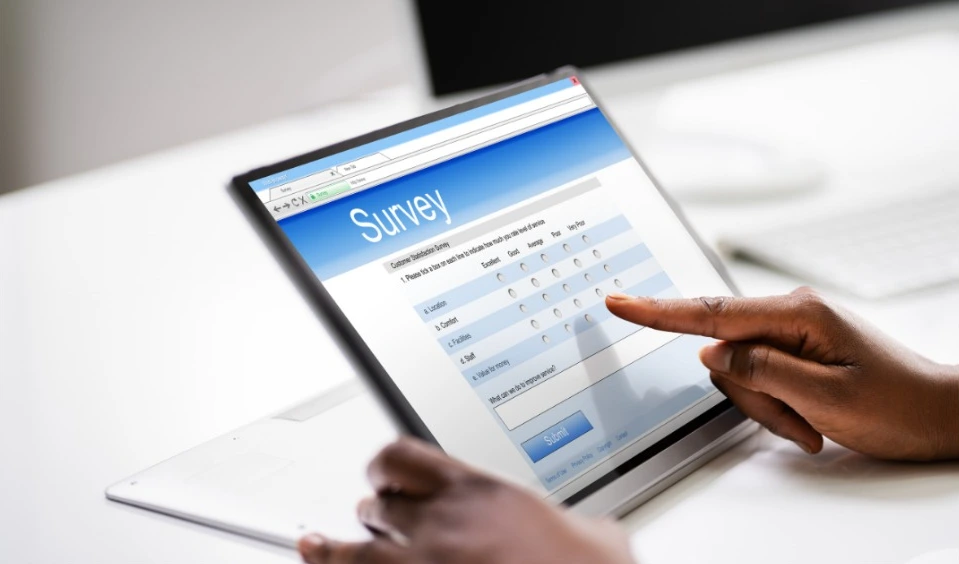 Person filling out an online survey form on a tablet device